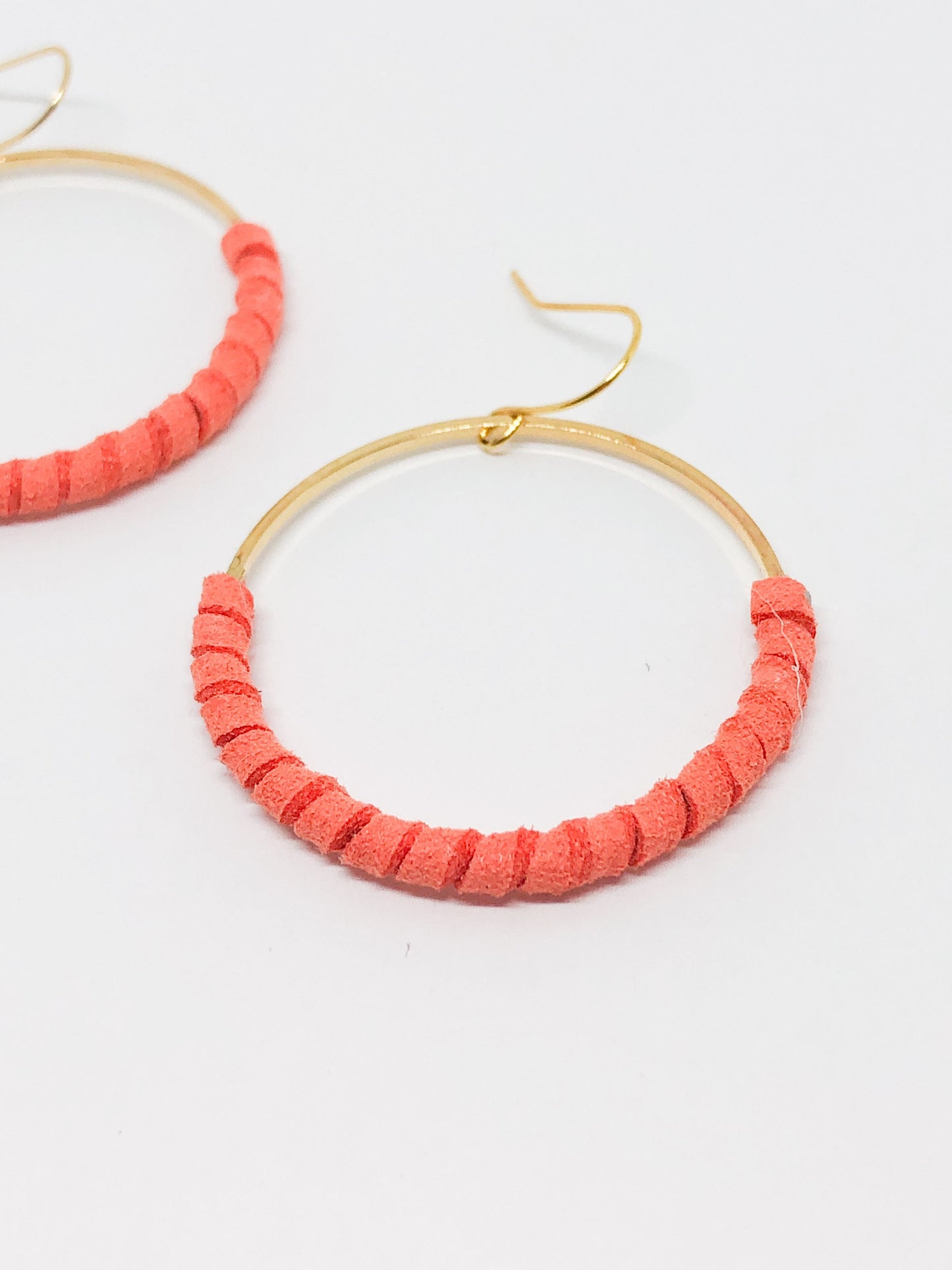 Gold hoop earrings with coral faux suede