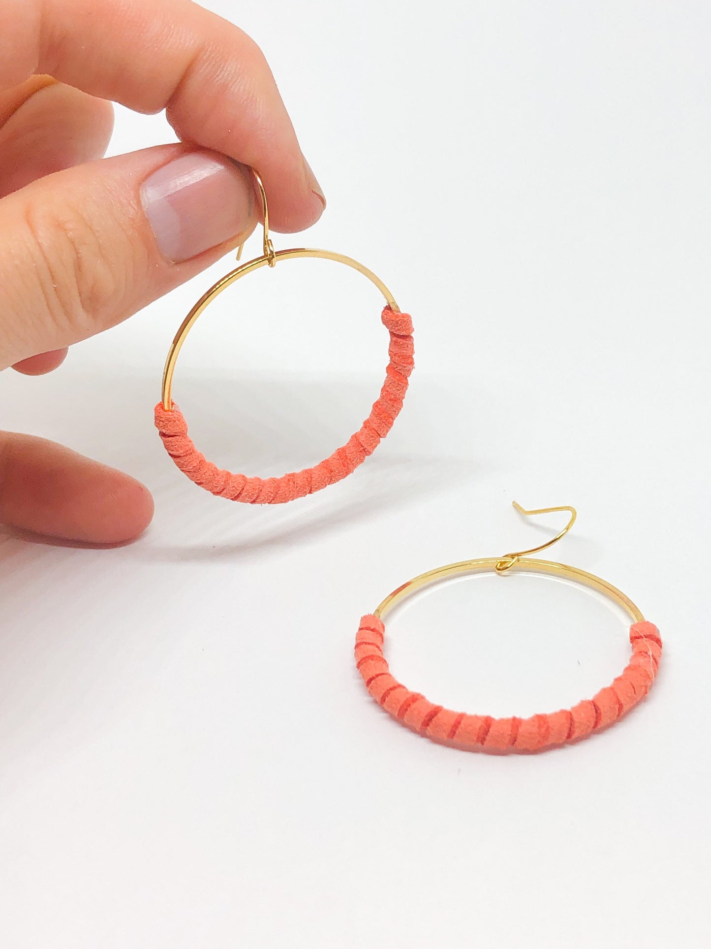 Gold hoop earrings with coral faux suede